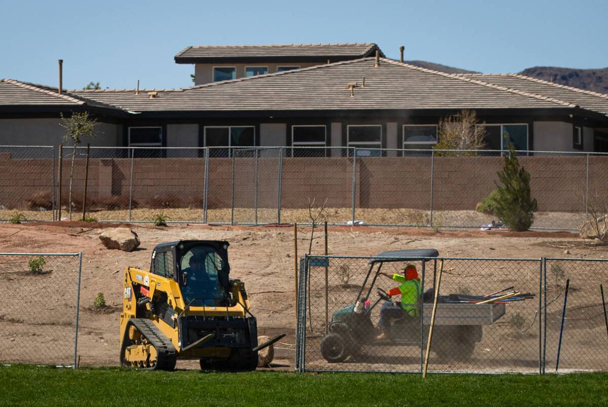 Workers make progress with updating the landscaping after removing some grass at Mission Hills ...