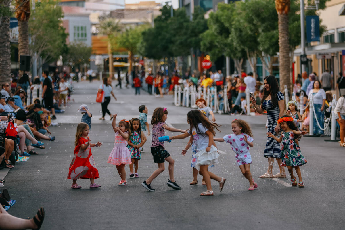 Children play along Park Centre Drive before the fourth annual Lei Day Parade on Thursday, May ...