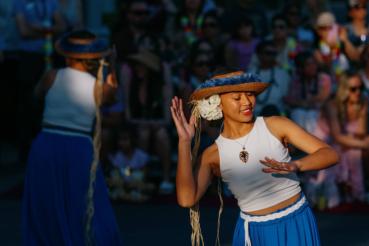 A dancer, illuminated in the afternoon sun, performs during the fourth annual Lei Day Parade on ...