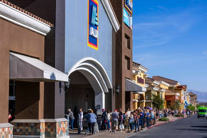 A line of customers waiting to enter stretches down the shopping center complex as Aldi is offi ...