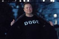 Elon Musk flashes his T-shirt that reads "DOGE" to the media as he walks on South Lawn of the W ...