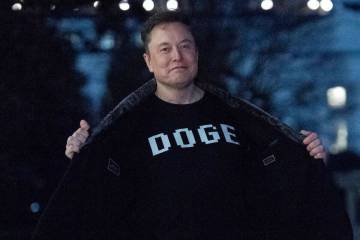 Elon Musk flashes his T-shirt that reads "DOGE" to the media as he walks on South Lawn of the W ...