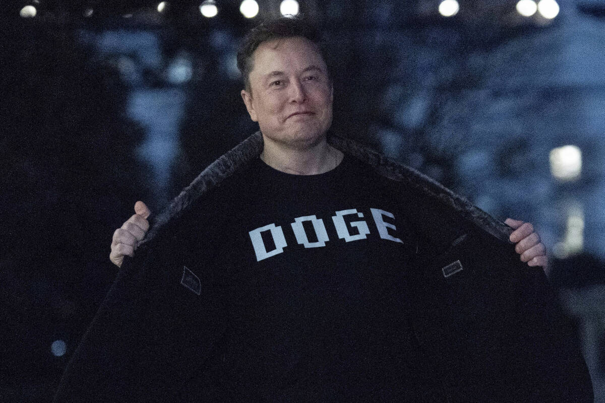 Elon Musk flashes his T-shirt that reads "DOGE" to the media as he walks on South Lawn of the W ...