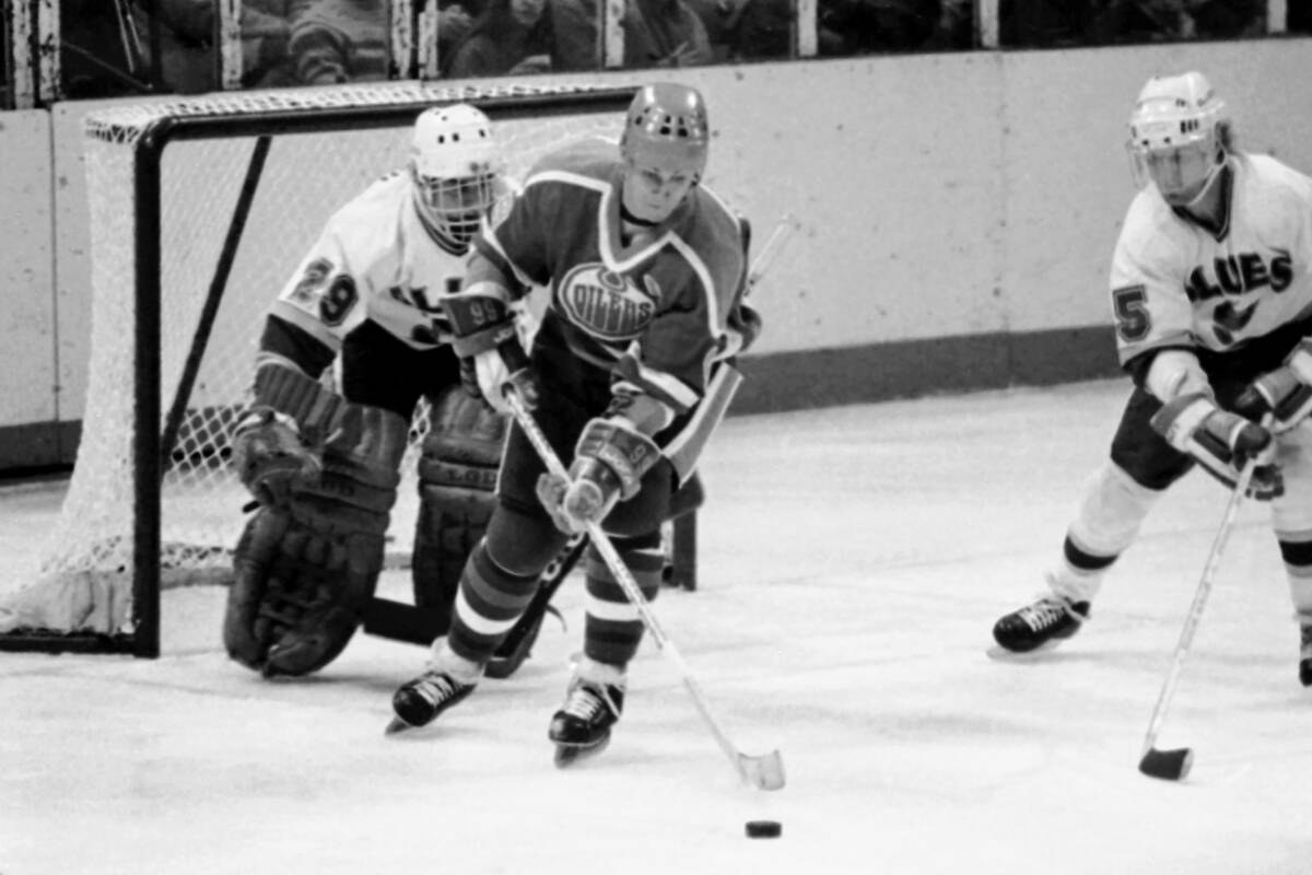 Edmonton Oilers' Wayne Gretzky (99) reaches out to handle the puck in front of St. Louis Blues' ...