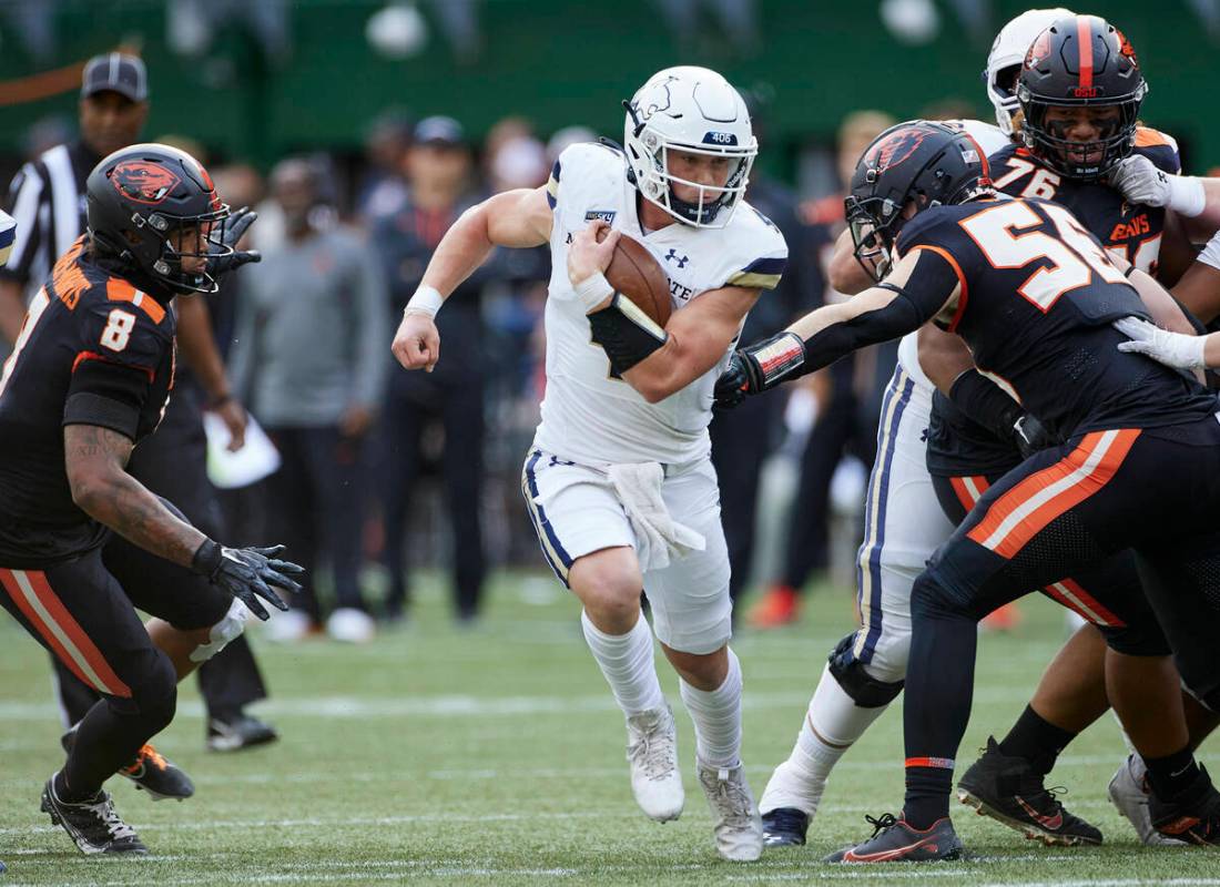 Montana State quarterback Tommy Mellott, center, runs past Oregon State linebacker Kyrei Fisher ...