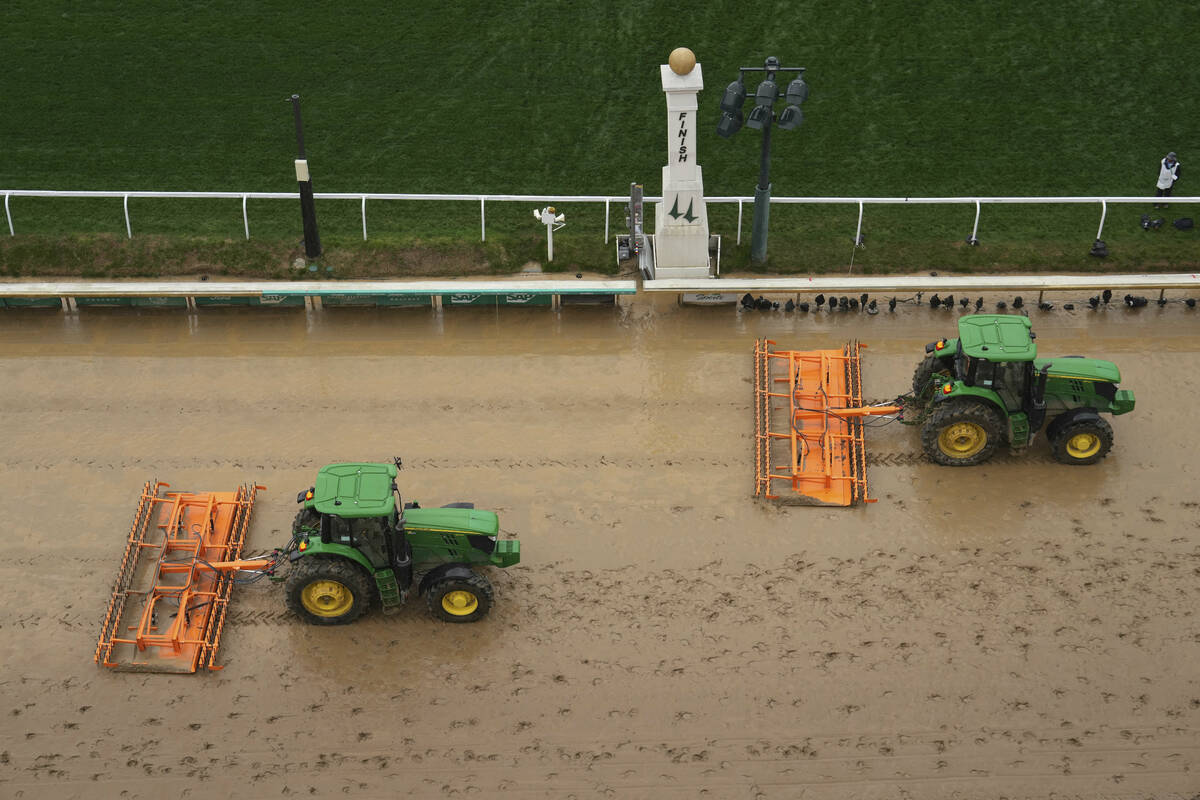 Tractors prepare the muddy track at Churchill Downs before the 151st running of the Kentucky De ...