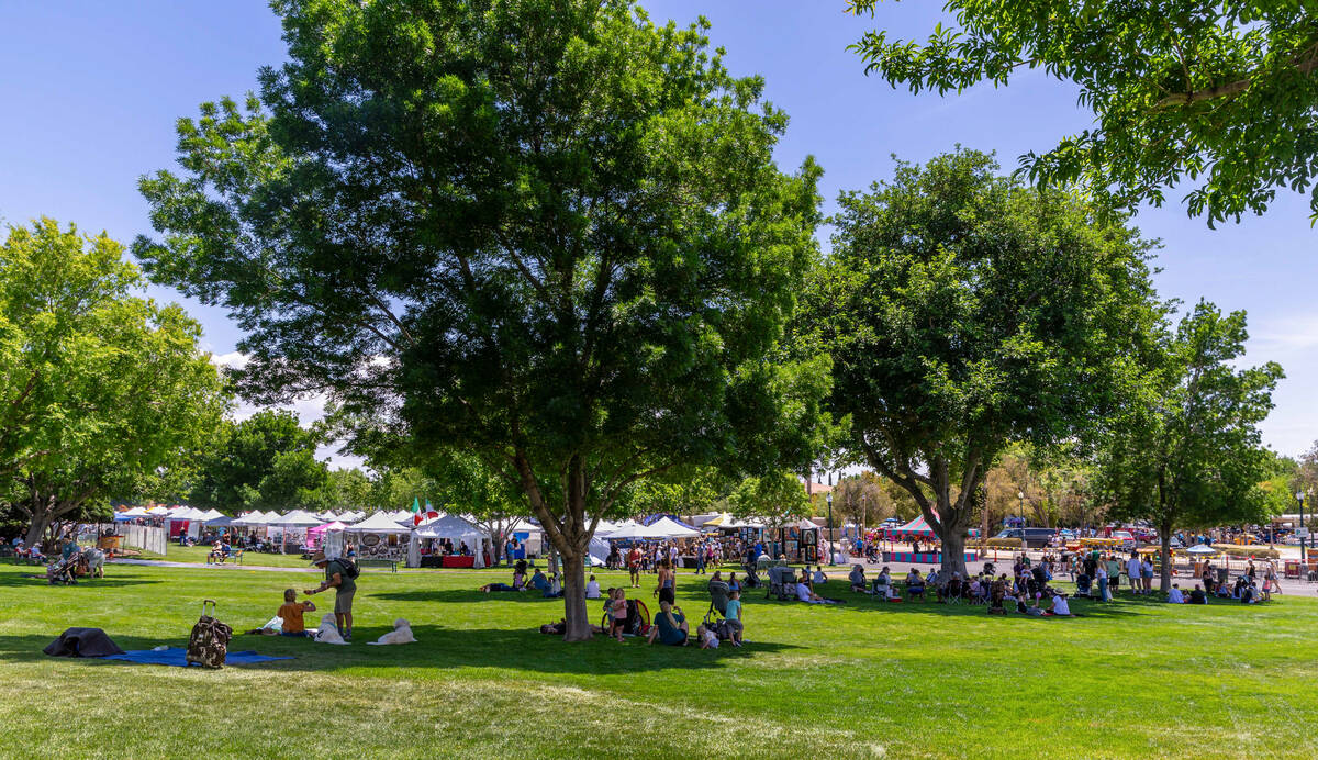 People relax in the shade while taking in the art and entertainment during the Spring Jamboree ...