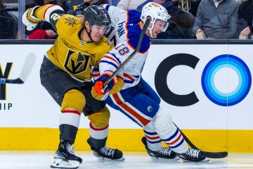 Golden Knights defenseman Zach Whitecloud (2) and Edmonton Oilers left wing Zach Hyman (18) bat ...