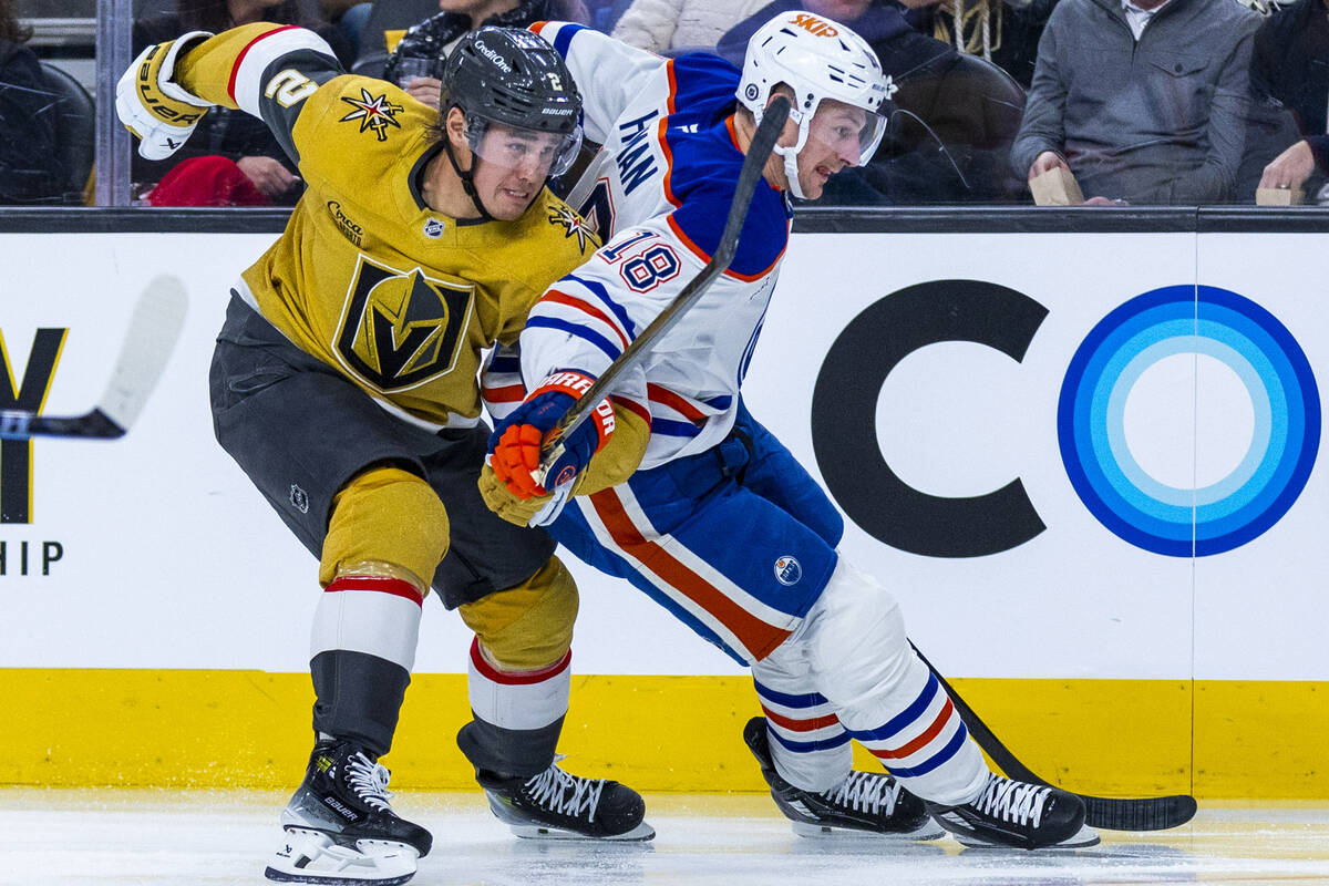 Golden Knights defenseman Zach Whitecloud (2) and Edmonton Oilers left wing Zach Hyman (18) bat ...