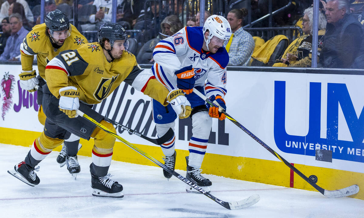 Golden Knights center Brett Howden (21) moves in on Edmonton Oilers left wing Max Jones (46) wi ...