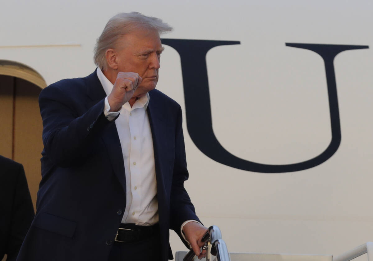 President Donald Trump gestures from the stairs of Air Force One upon his arrival at Joint Base ...