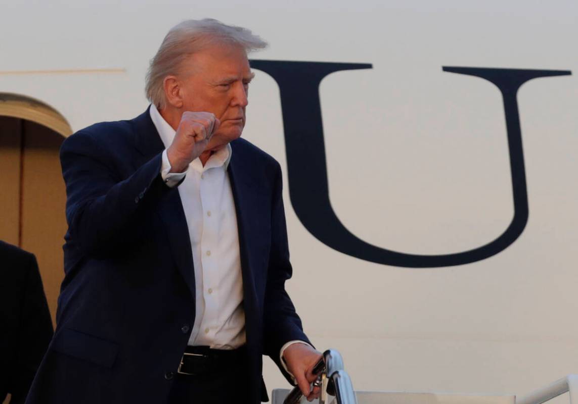 President Donald Trump gestures from the stairs of Air Force One upon his arrival at Joint Base ...