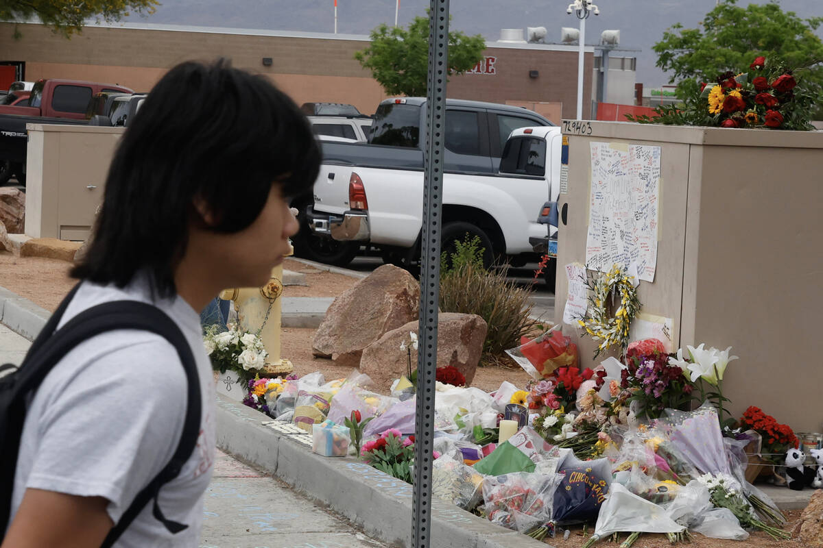 A student at Arbor View High School walks past a makeshift memorial for McKenzie Scott, a senio ...