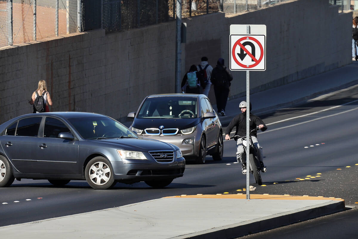 A student on an e-dirt bike swerves around a car making an illegal u-turn on Coronado Center Dr ...