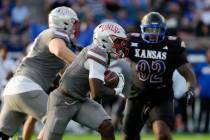 UNLV running back Jai'Den Thomas, center, runs the ball against Kansas in the first half of an ...
