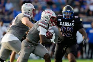 UNLV running back Jai'Den Thomas, center, runs the ball against Kansas in the first half of an ...