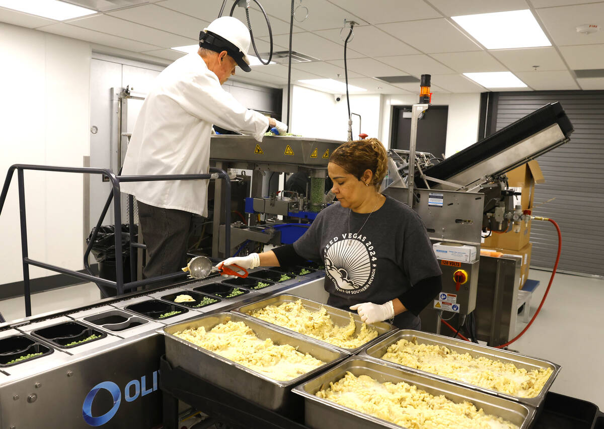 Workers for Meals on Wheels prepare meals for clients at Catholic Charities of Southern Nevada ...
