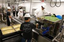 Workers for Meals on Wheels prepare food for clients at Catholic Charities of Southern Nevada M ...