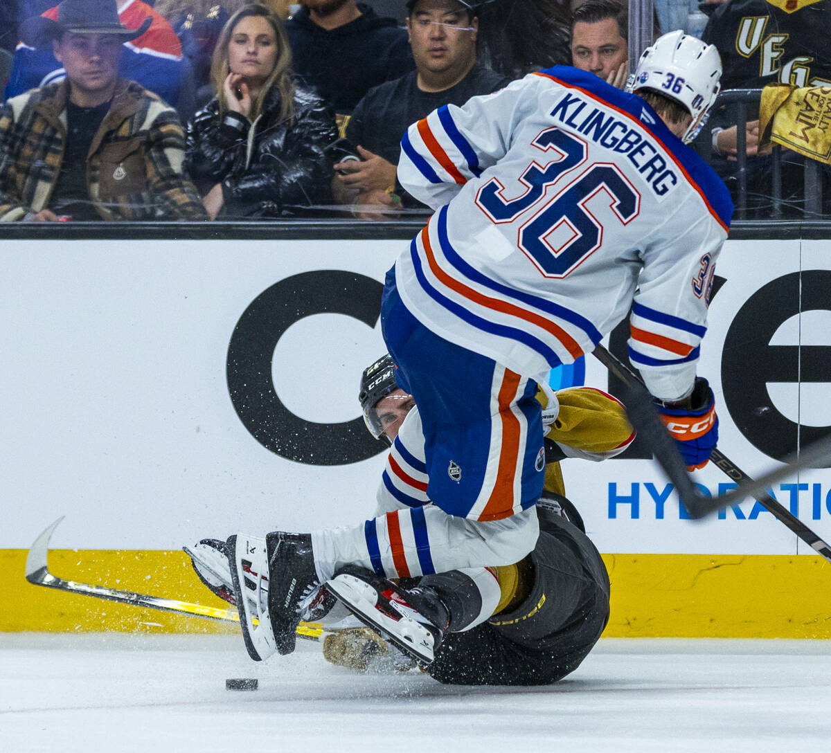 Golden Knights center Brett Howden (21) is checked to the ice by Edmonton Oilers defenseman Joh ...
