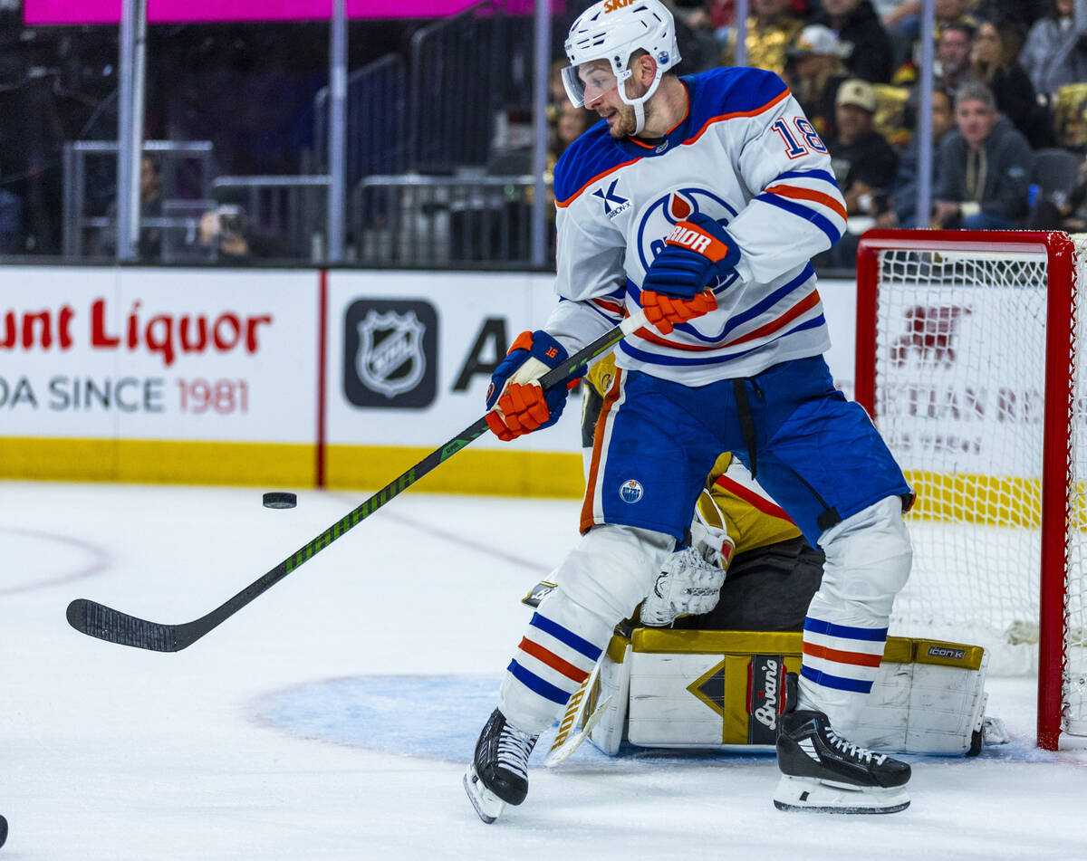 Edmonton Oilers left wing Zach Hyman (18) deflects a shot at Golden Knights goaltender Adin Hil ...