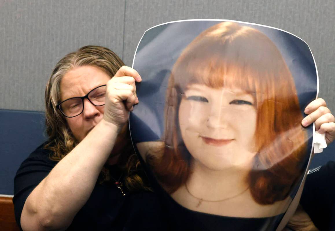 Tiffany Reynolds holds a photograph of her daughter McKenzie Scott as she attends a hearing for ...