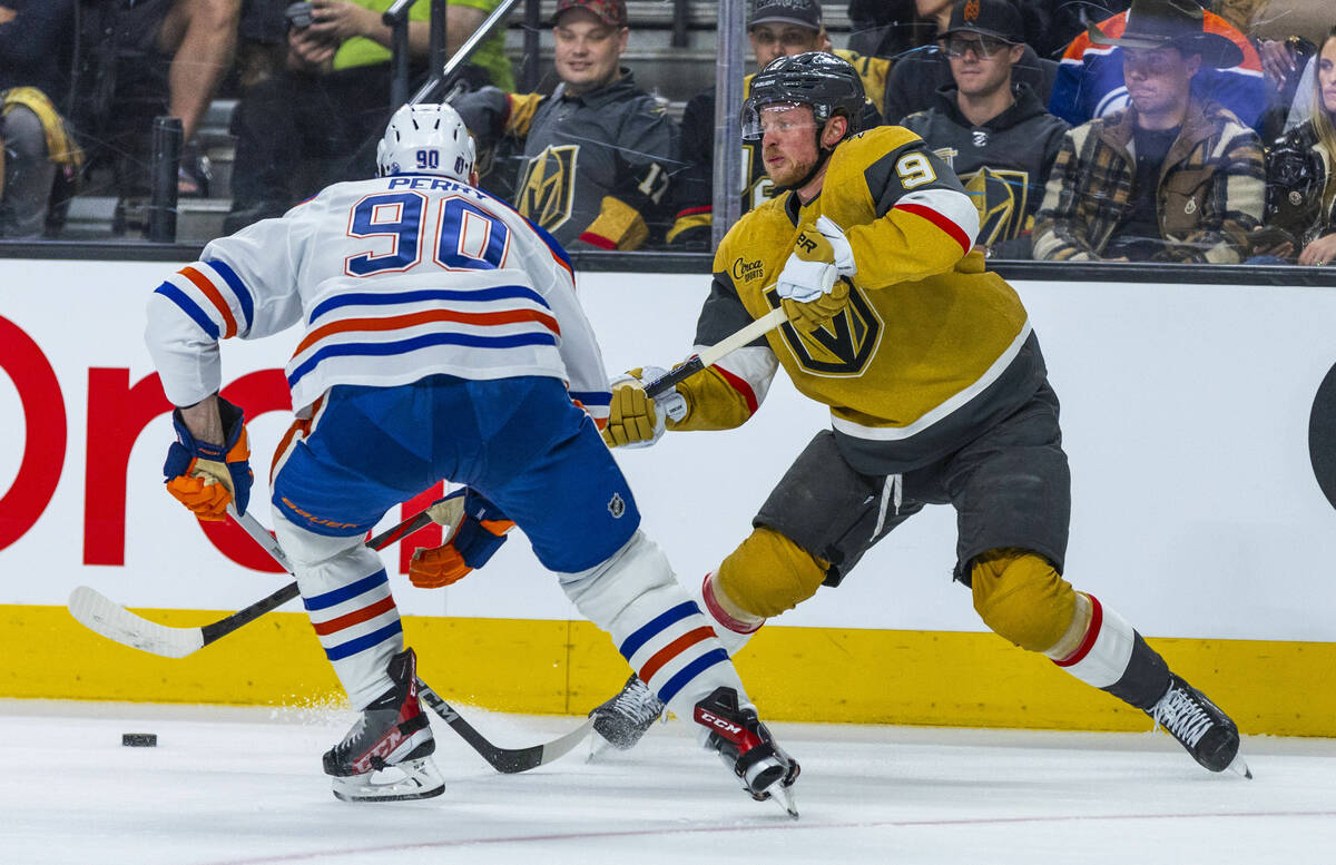 Golden Knights center Jack Eichel (9) passes as Edmonton Oilers right wing Corey Perry (90) mov ...