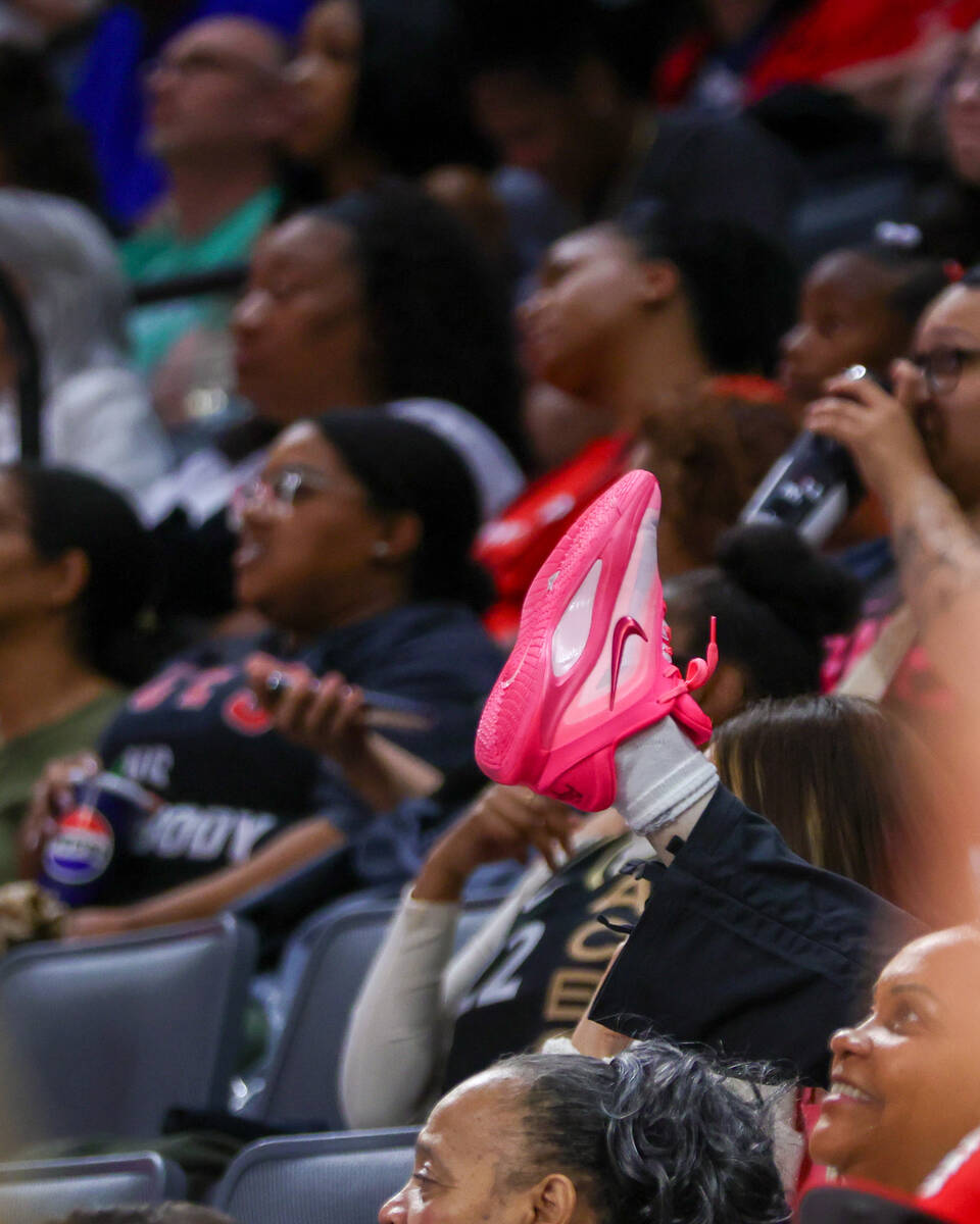 A fan lifts up their A’ja Wilson A’One Nikes during a pre-season game against Pho ...