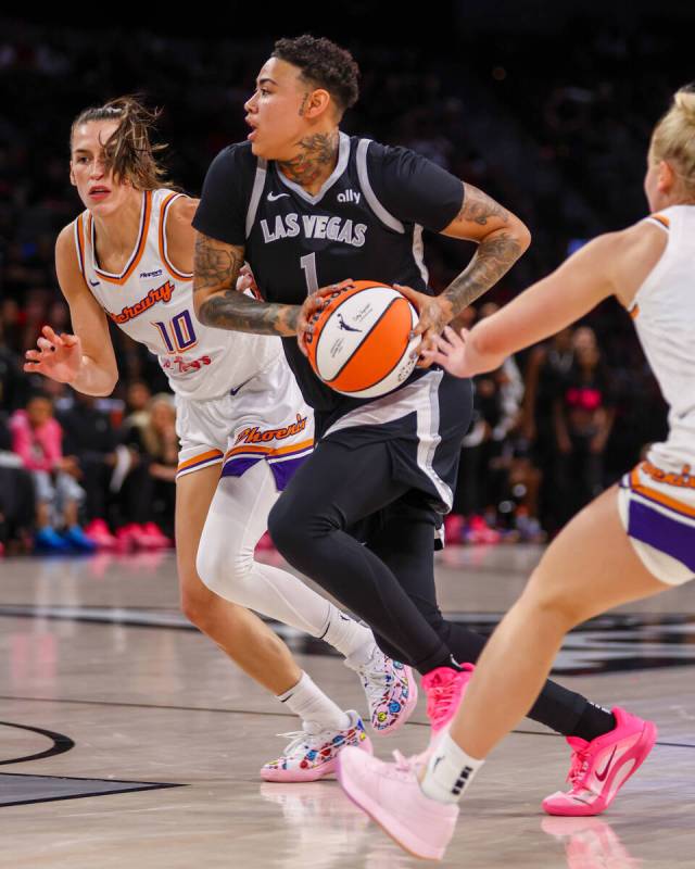 Aces forward Kierstan Bell (1) pushes her way past Phoenix Mercury guards Sevgi Uzun (10) and S ...