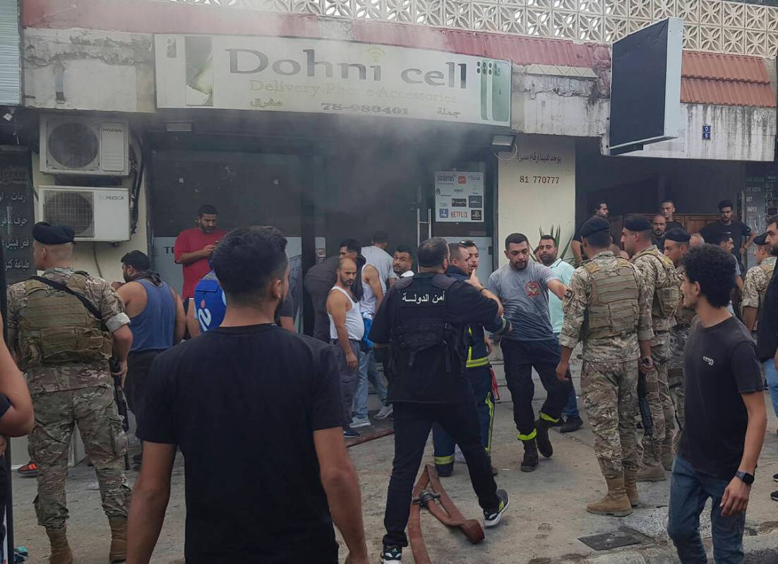 Lebanese soldiers and firefighters gather outside a mobile shop after what is believed to be th ...