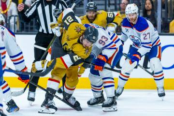 Golden Knights center Brett Howden (21) deflects a puck off his skate as he faces off with Edmo ...
