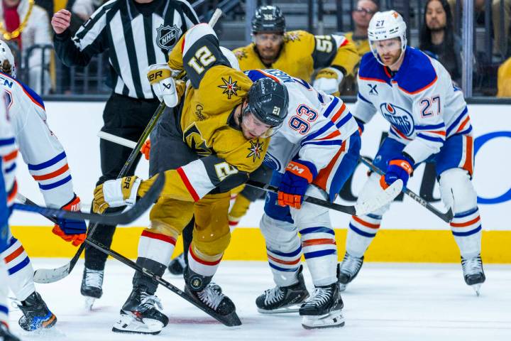 Golden Knights center Brett Howden (21) deflects a puck off his skate as he faces off with Edmo ...