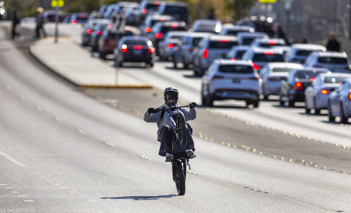 A student riding an e-dirt bike pop a wheelie along Coronado Center Drive from Coronado High Sc ...