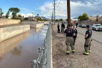 Henderson police officers and firefighters investigate the scene of a swift-water rescue near P ...