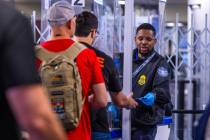 A traveler receives his identification back after verification at the TSA security checkpoint a ...