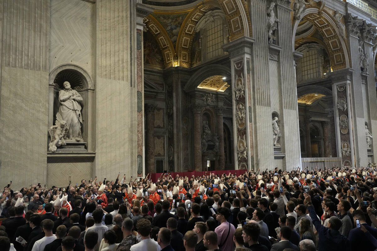 Faithful capture images with their smartphones of cardinals arriving during a final Mass inside ...