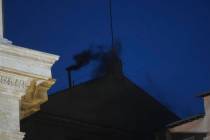 Black smoke billows from the chimney of the Sistine Chapel during the cardinals' conclave to el ...