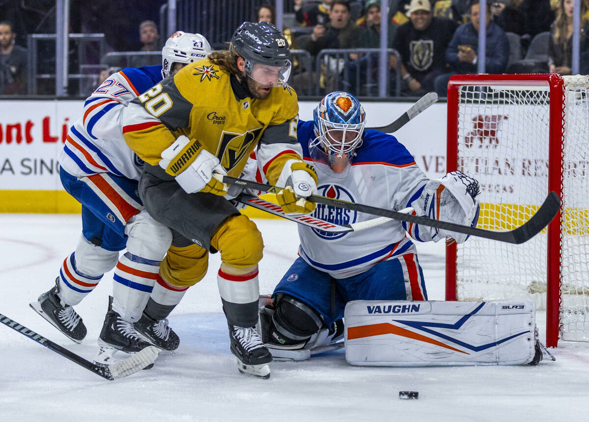 Golden Knights left wing Brandon Saad (20) battles to get a shot off past Edmonton Oilers defen ...