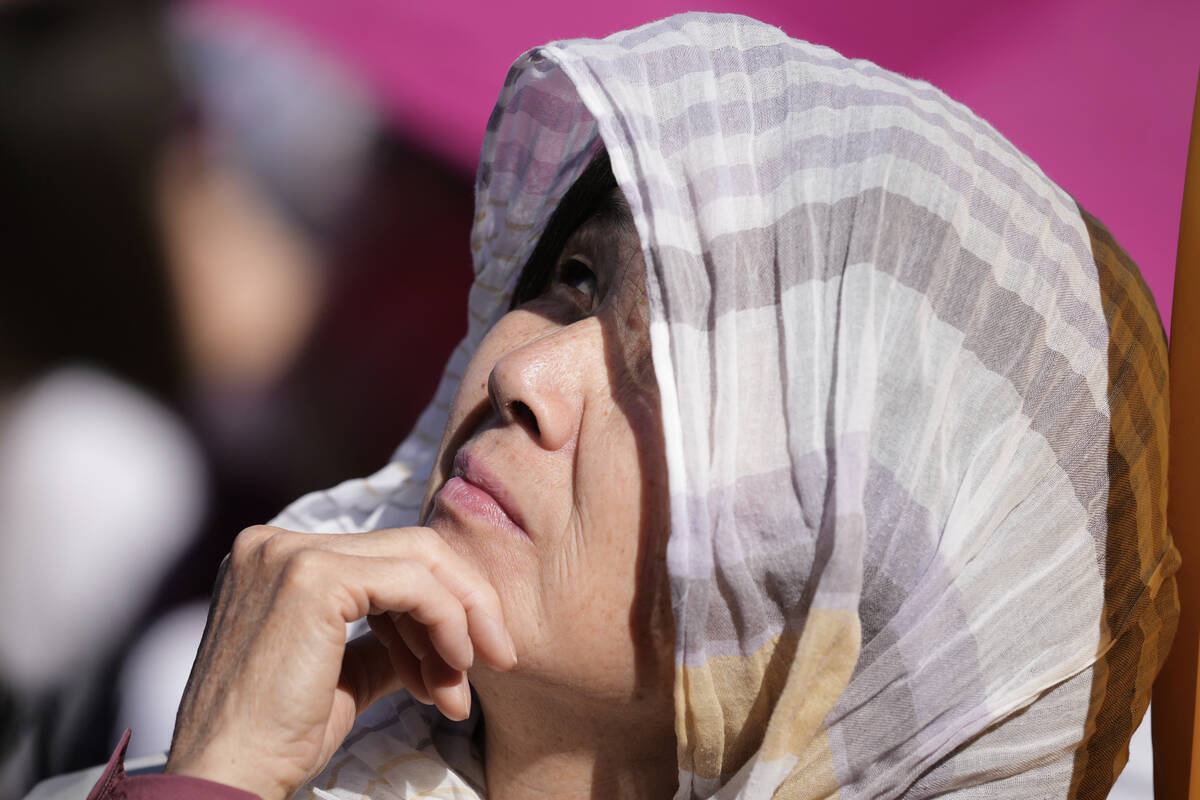 A woman looks up during the conclave to elect a new pope, in St. Peter's Square, at the Vatican ...