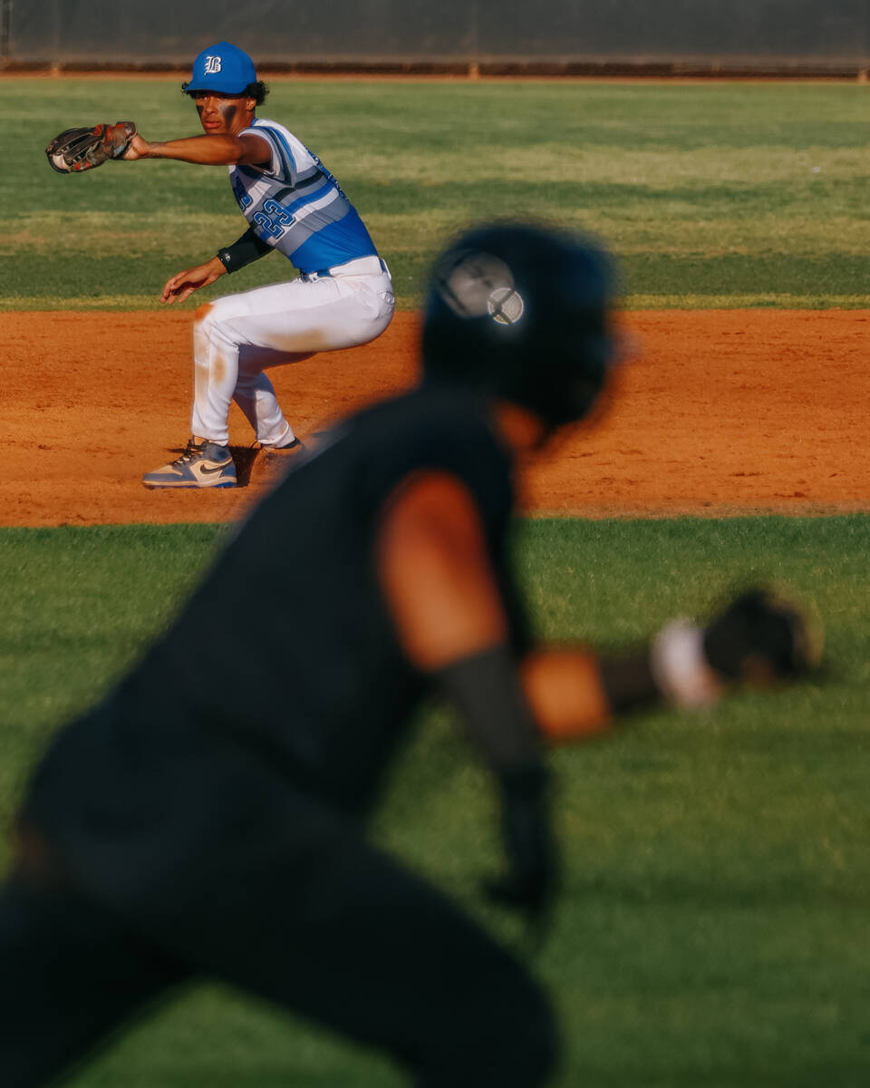 Basic infielder Matthew Kelley (23) grabs a ground ball as a Faith Lutheran runner sprints towa ...