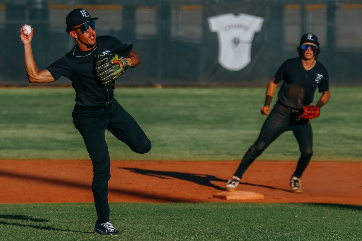 Faith Lutheran’s Rouselle Shepard (5) winds back to toss to first for a putout during th ...