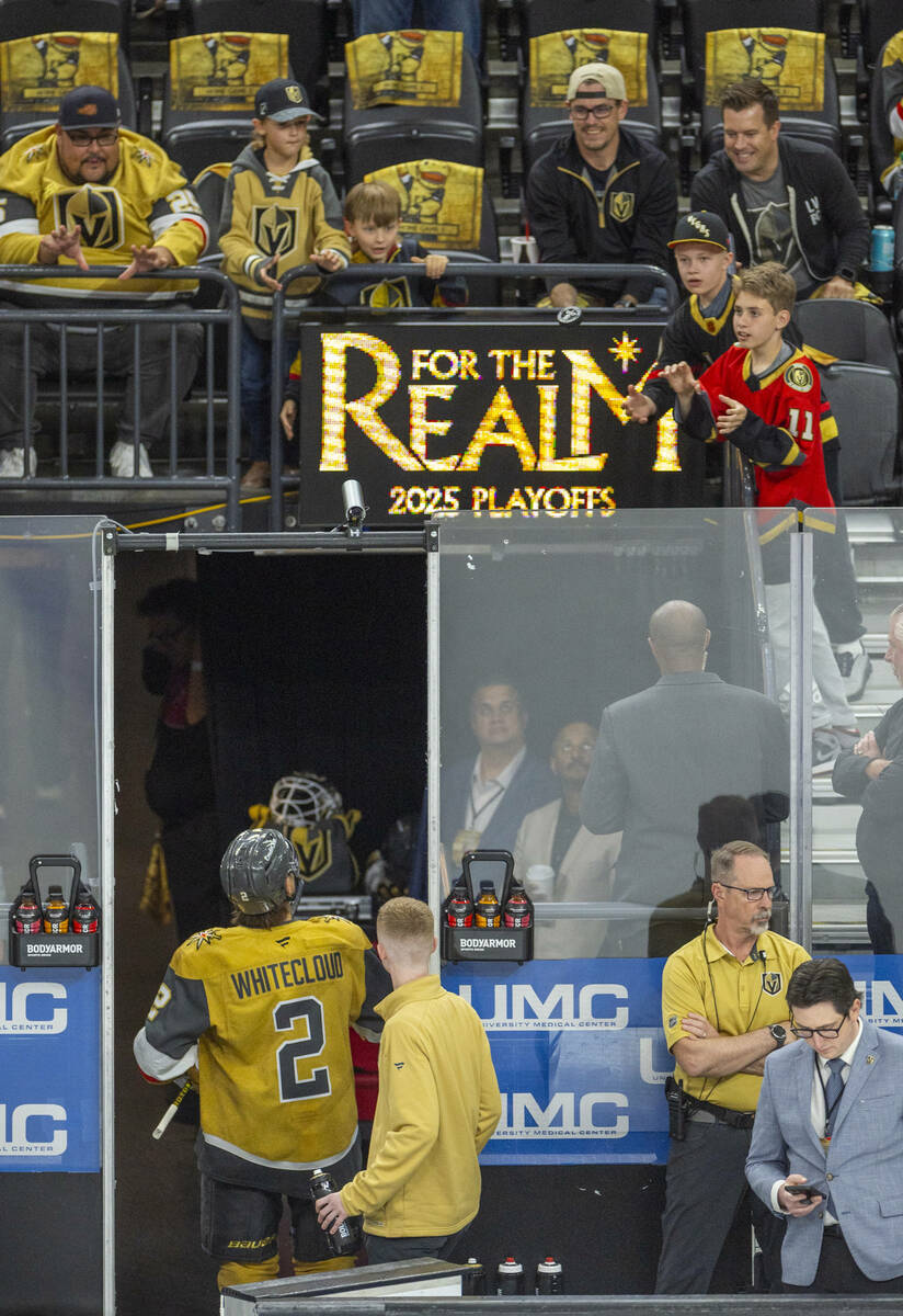 Golden Knights defenseman Zach Whitecloud (2) tosses a puck to fans during the warm up period o ...