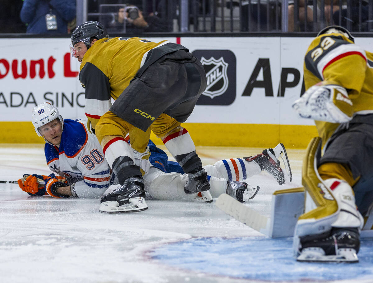 Edmonton Oilers right wing Corey Perry (90) is taken down to the ice by Golden Knights defensem ...