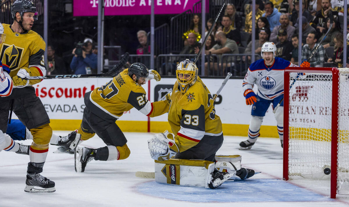The puck gets past Golden Knights goaltender Adin Hill (33) as the Edmonton Oilers score during ...