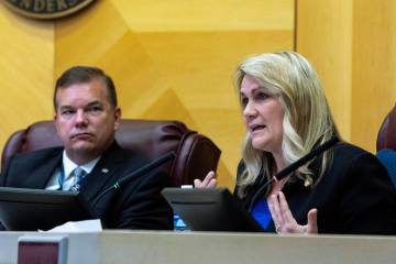 Council member Carrie Cox speaks with Jim Seebock nearby during a Henderson City Council meetin ...