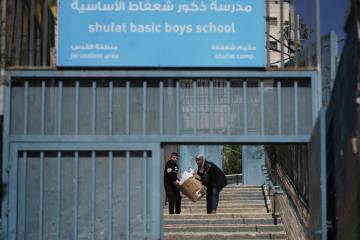 A student and a teacher carry study material at UNRWA Girls School run by the U.N. agency for P ...