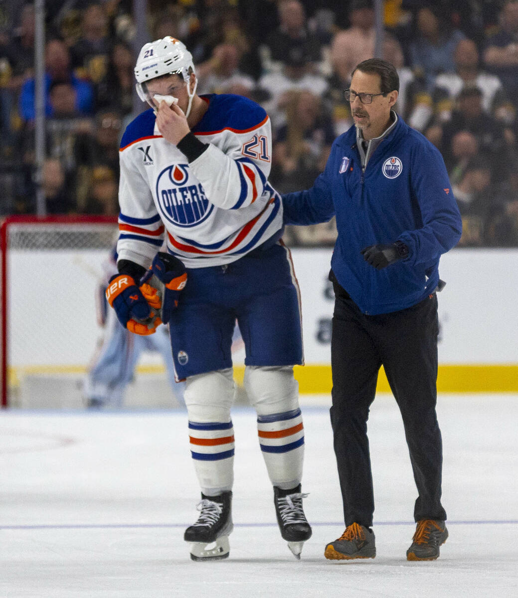 Edmonton Oilers center Trent Frederic (21) is escorted after a stick to the face by Golden Knig ...