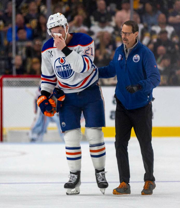 Edmonton Oilers center Trent Frederic (21) is escorted after a stick to the face by Golden Knig ...