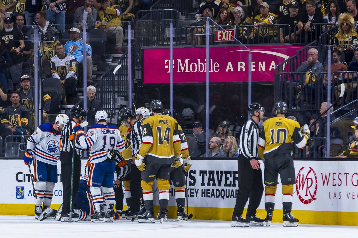 Players attend to Edmonton Oilers center Trent Frederic (21) after a stick to the face by Golde ...