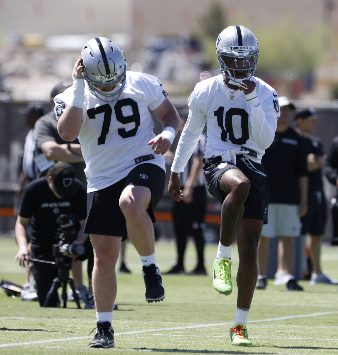 Raiders defensive line Laki Tasi (79) and wide receiver Donte Thornton Jr. (10) warm up during ...