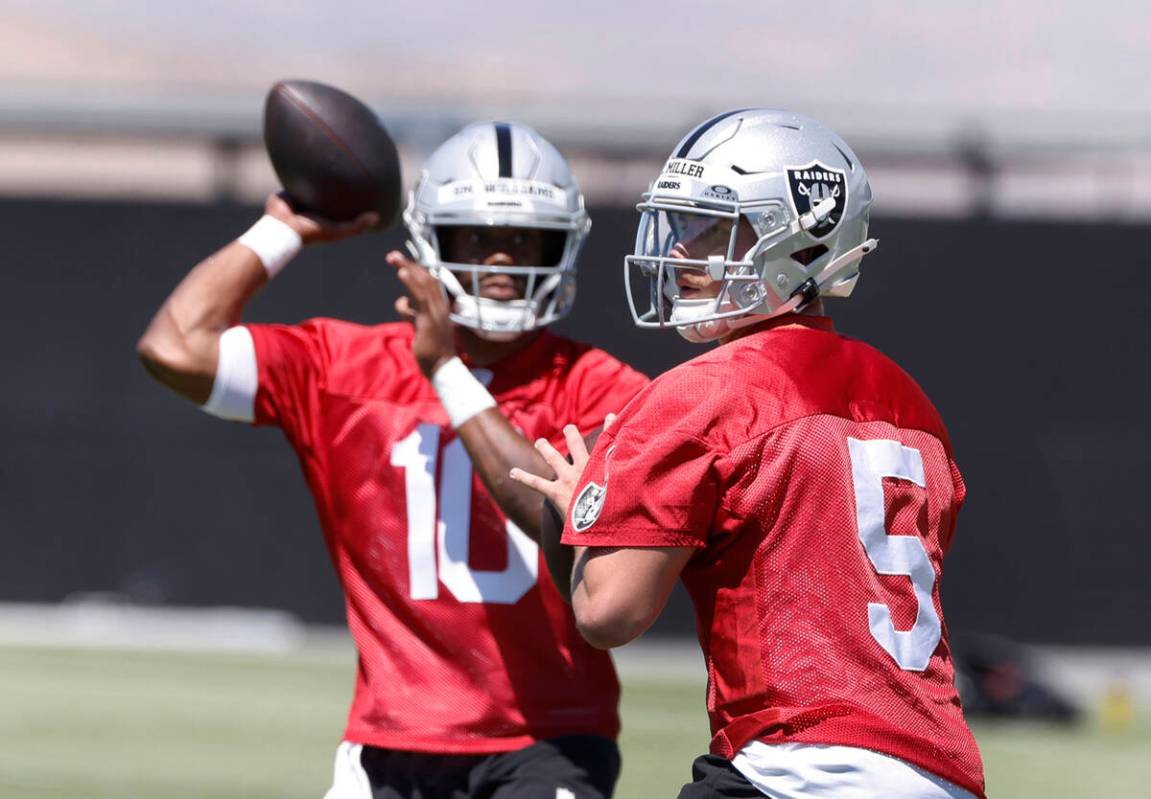 Raider quarterback Cam Miller (5) and former UNLV quarterback Hajj-Malik Williams, left, prepar ...